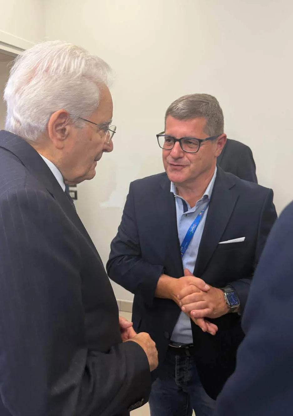 Il Presidente della Repubblica Sergio Mattarella e il dirigente scolastico Salvatore Giuliano conversano in una stanza.